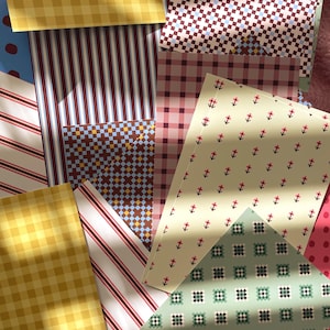 May include: A collection of rectangular paper sheets featuring various patterns including yellow gingham, red and white stripes, blue and brown geometric grids, pink plaid, a cream background with small red floral motifs, and a sage green grid pattern.