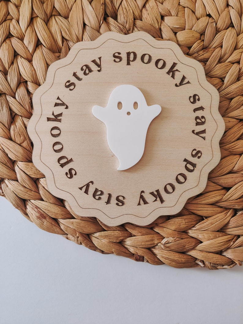 May include: A wooden sign with a white ghost cutout and the text "stay spooky stay spooky" around the edge.