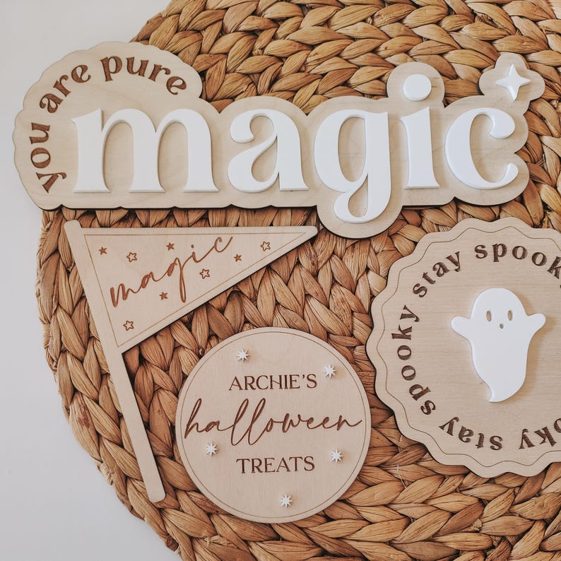 May include: Wooden Halloween decorations with the words "You are pure magic", "magic", "Archie's Halloween Treats", and "Spooky stay spooky stay spooky". The decorations are on a woven wicker background.