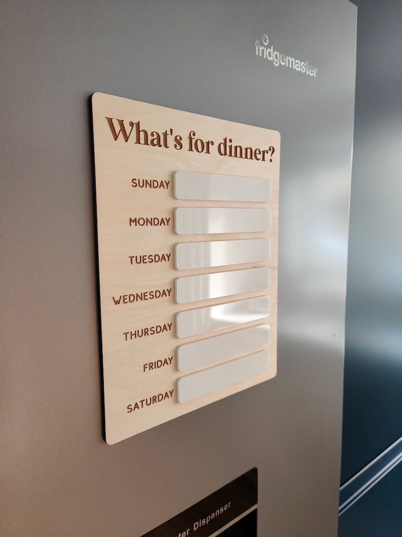 May include: A wooden weekly meal planner with the text "What's for dinner?" and blank white spaces for each day of the week: Sunday, Monday, Tuesday, Wednesday, Thursday, Friday, and Saturday.