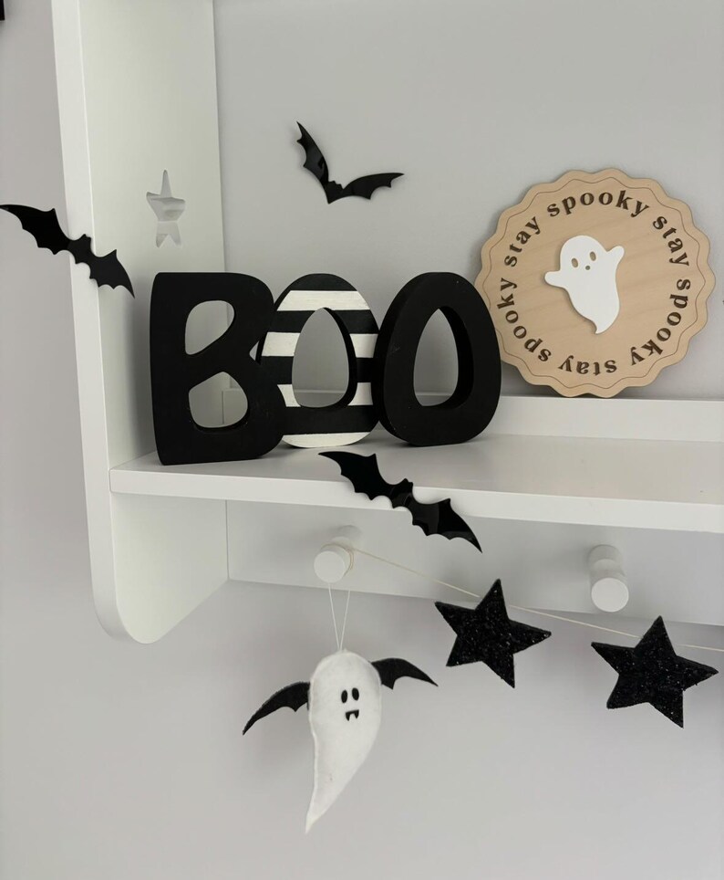 May include: Black and white wooden BOO letters with a black and white striped O, a white ghost with a black face, and a wooden sign that says "Stay spooky stay spooky stay spooky" with a white ghost in the center.