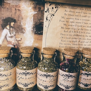 Puede incluir: Cinco peque&ntilde;os frascos de vidrio con tapas de corcho llenos de hierbas y flores secas. Cada frasco tiene una etiqueta con un nombre y una descripci&oacute;n diferentes. Las etiquetas son de estilo vintage con letras negras sobre fondo marr&oacute;n. Los frascos est&aacute;n sobre una superficie de madera. El texto en las etiquetas dice: "Order", "Peppermint", "Common Balm", "Rose", "Amon".