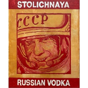 以下が含まれることがあります： 金色を背景に、赤い宇宙服を着た宇宙飛行士のヴィンテージスタイルのイラスト。赤い文字で「Stolichnaya」と「Russian Vodka」の文字が書かれている。赤い文字で「CCCP」の文字が書かれている。