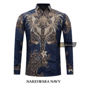 Op de afbeelding: Een donkerblauw overhemd met lange mouwen met een traditioneel batikpatroon met een feniksontwerp. Het overhemd heeft een knoopsluiting en een gouden en zwarte kleurstelling. De tekst "Nareswara Navy" is onder het overhemd gedrukt.