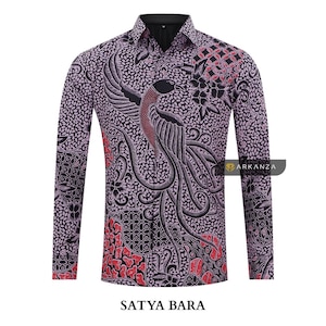 Puede incluir: Una camisa de manga larga con fondo morado y un patrón batik negro y rojo con un diseño de pájaro. La camisa tiene un cuello abotonado y un bolsillo en el pecho izquierdo. El texto "SATYA BARA" está impreso debajo de la camisa.