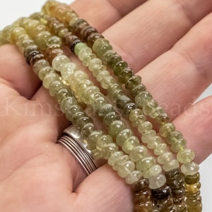 May include: A strand of green and brown gemstone beads. The beads are round and have a smooth, polished finish.