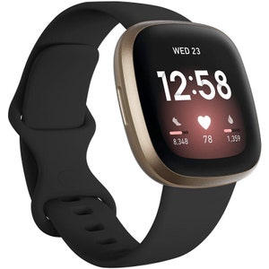 May include: A gold-coloured smartwatch with a black silicone strap. The watch face displays the time, date, and heart rate. The watch face also shows the number of steps taken, heart rate, and calories burned.
