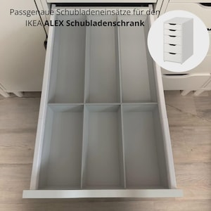Op de afbeelding: Een witte lade-organizer met zes rechthoekige vakken in een open witte lade. De tekst luidt Passgenaue Schubladeneinsätze für den IKEA ALEX Schubladenschrank, met een afbeelding van een ladekast met vijf laden in de hoek.
