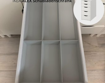 May include: A white drawer organizer insert with six rectangular compartments installed inside an open white drawer. The text reads Passgenaue Schubladeneinsätze für den IKEA ALEX Schubladenschrank, with an inset graphic of a five-drawer unit.