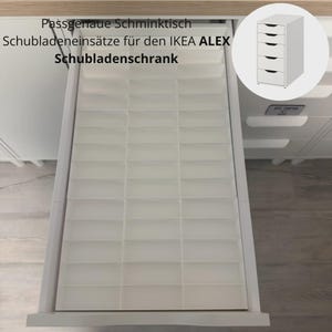 Peut inclure: Un insert de tiroir en plastique blanc avec de multiples compartiments rectangulaires conçu pour une unité de tiroirs IKEA ALEX. Le texte Passgenaue Schminktisch Schubladeneinsätze für den IKEA ALEX Schubladenschrank est visible en haut.