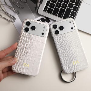 Könnte beinhalten: Ein Set aus drei Keramikbechern mit gesprenkelter, matter Oberfläche. Die Becher sind in den Farbtönen Creme, Hellgrau und Dunkelgrau gehalten. Jeder Becher hat ein schlichtes, minimalistisches Design, ideal für Kaffee oder Tee.