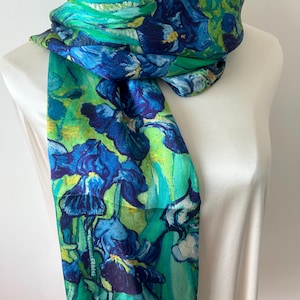 May include: A green silk scarf with a blue and green floral print. The print is reminiscent of a famous painting of irises.