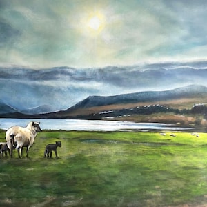 Op de afbeelding: Een schilderij van een schaap en twee lammeren in een weiland, met een meer en bergen op de achtergrond. De lucht is bewolkt en de zon schijnt door de wolken.