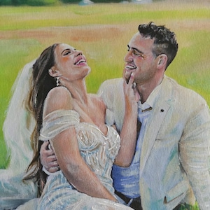 May include: A painted portrait of a newly married couple. The bride is in a white, decorated wedding dress and veil. The groom wears a white suit. They are sitting on grass, smiling and laughing. The background is a green field.