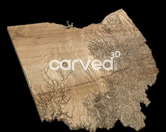 May include: A 3D relief map of the state of Ohio, carved from wood. The map shows the state's topography, with the highest elevations in the eastern and southern parts of the state. The map is a light brown color, and the text "carved3d.com" is visible in the center of the map.
