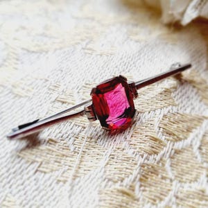Spilla/fermaglio in argento 925 del periodo Art Déco con punzone del cinghiale e vetro color rubino.