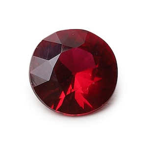 Op de afbeelding: Een ronde, rode edelsteen met een facetgeslepen vorm.