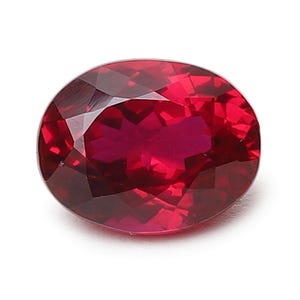 May include: A deep red oval-shaped gemstone with a faceted cut.