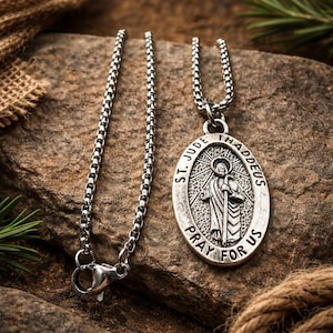 Op de afbeelding: Een zilverkleurige ketting met een hanger met een afbeelding van St. Jude Thaddeus. De ovale hanger heeft de inscripties "ST. JUDE THADDEUS" en "PRAY FOR US". De ketting heeft een schakelontwerp.