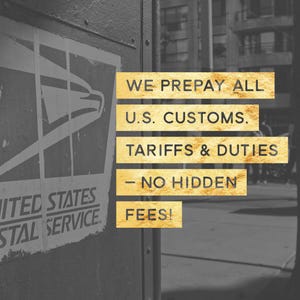 May include: A black and white United States Postal Service logo on a dark surface with gold text overlays that read: WE PREPAY ALL U.S. CUSTOMS, TARIFFS & DUTIES - NO HIDDEN FEES! The text is presented in five separate horizontal gold-coloured rectangular blocks.