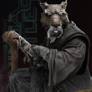 Könnte beinhalten: Eine detaillierte, graue und schwarze, geformte Figur eines Ratten in einer schwarzen Robe, der ein Schwert hält. Die Ratte hat einen weißen Bart und Schnurrbart und einen strengen Ausdruck.