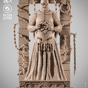 May include: A 1/6 scale tan resin figure of a bald, bespectacled character with a textured torso and a long skirt featuring a tool belt. The figure stands before a stone-like frame adorned with hanging chains and hooks, with text reading PRESUPPORTED TESTED, SCALE 1/6, RESIN & FDM, and WICKED.