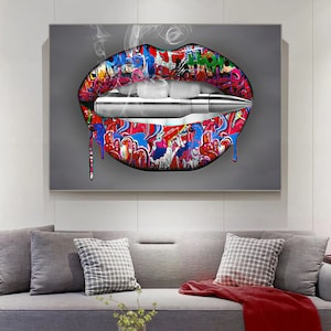 May include: A colorful, graffiti-style image of a pair of lips with a bullet in between them. The lips are red, pink, and blue, and the bullet is silver. There is smoke coming from the lips, and the background is gray.