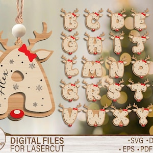 Puede incluir: Adornos navideños de madera con forma de letras, cada uno adornado con cuernos de reno y un lazo rojo. La letra "A" tiene el nombre "Alex" inscrito. El conjunto incluye todo el alfabeto, perfecto para la decoración navideña personalizada.