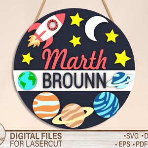 May include: A round, black and blue sign with a rocket ship, stars, a crescent moon, and planets. The sign says "Marth Brounn" in red and white letters.