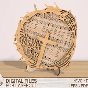 May include: A laser cut wooden design of a cross with a crown of thorns and the words "The Old Rugged Cross" on it. The design is based on a hymn sheet with musical notes.