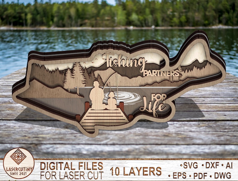 May include: A wooden layered cutout of a bass fish with a lake scene and two figures fishing from a dock. The text "Fishing Partners for Life" is included in the design. This is a digital file for laser cutting.