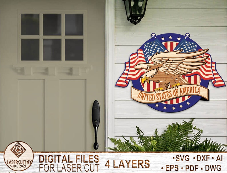 May include: A wooden cutout of an American bald eagle with wings spread, holding a banner that reads "United States of America". The eagle is surrounded by two crossed American flags and a blue circle with white stars. The cutout is designed for laser cutting and has four layers.