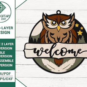 May include: Multi-layer wooden owl sign with the word "welcome" on a banner. The owl is brown with yellow eyes and is surrounded by a green forest scene with stars.