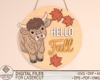 May include: A round wooden sign with a Highland cow illustration and the words "HELLO Fall". The sign features orange maple leaves and is designed for laser cutting. Includes digital file formats: SVG, DXF, AI, EPS, PDF, and DWG.