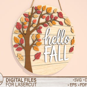 May include: A round wooden sign with a tree design and the words "hello FALL" in white. The tree has brown branches and colorful leaves in shades of red, orange, and yellow. The sign is hanging by a rope.