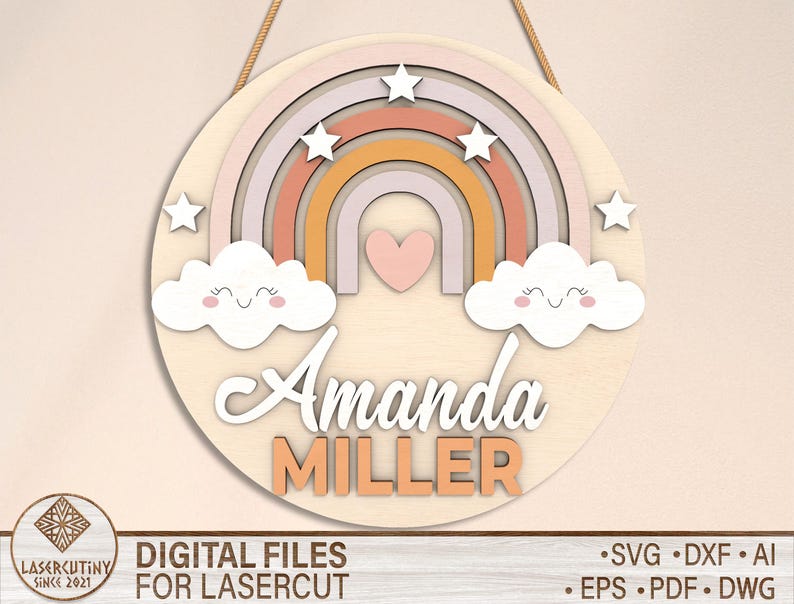May include: A wooden rainbow with pink, orange, and yellow stripes, two white clouds with smiling faces, and a pink heart. The rainbow has a white background with the name "Amanda Miller" written in a cursive font.