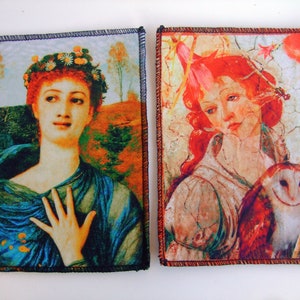 Peut inclure: Deux pièces d'art textile avec des portraits de femmes classiques. L'une représente une femme avec une couronne florale et des vêtements drapés bleus. L'autre représente une femme aux cheveux roux et un hibou. Les deux ont des bordures cousues noires.