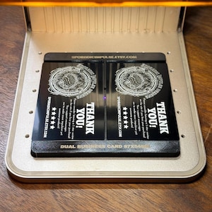 May include: Two black dual business cards with white text and a circular design are displayed inside a silver case. The cards read "THANK YOU!" and include the website address SPORADICIMPULSE.ETSY.COM. The cards also have a 5-star review request.