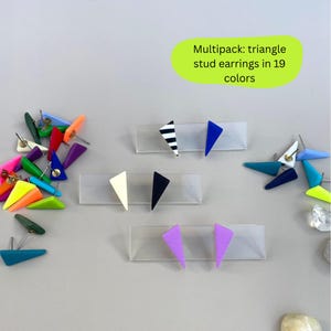 May include: A collection of triangle stud earrings in various colors, including blue, black, white, and purple. Some earrings feature striped patterns. The image includes text that reads "Multipack: triangle stud earrings in 19 colors."