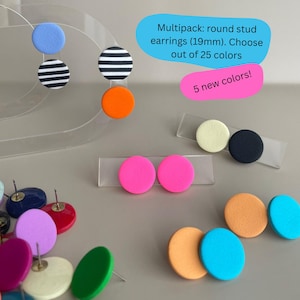 Op de afbeelding: Een verzameling ronde oorstekers in diverse kleuren, waaronder blauw, zwart-wit gestreept, oranje en roze. De oorbellen hebben een diameter van ongeveer 1,9 cm. De tekst op de afbeelding luidt: "Multipack: ronde oorstekers (19mm). Kies uit 25 kleuren."