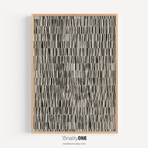 Puede incluir: Impresión de arte abstracto con un patrón geométrico de líneas negras, blancas y grises. La impresión está enmarcada en un marco de madera natural.