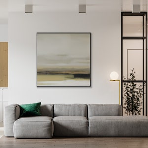 May include: A gray sectional sofa with a green velvet pillow in a modern living room with a framed abstract painting on the wall and a floor lamp with a white globe.