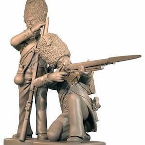 May include: A monochromatic light brown figurine set featuring two soldiers in tall fur caps. One soldier stands holding a musket with a bayonet, while the other kneels in a firing position, aiming a musket with a fixed bayonet forward.