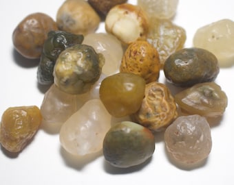 May include: A collection of smooth, polished agate stones in various shades of brown, white, and green. The stones are tumbled and have a natural, earthy look.