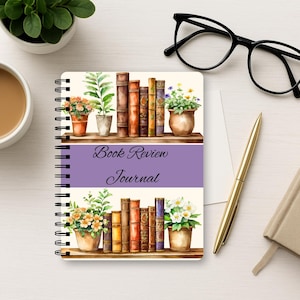 Puede incluir: Un diario de rese&ntilde;as de libros con encuadernaci&oacute;n en espiral que presenta una ilustraci&oacute;n en acuarela de dos estantes de madera llenos de libros de tapa dura y plantas en macetas. Una banda central morada muestra el texto Book Review Journal.