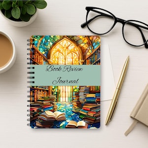Puede incluir: Un diario de espiral con una colorida ilustraci&oacute;n de una biblioteca con vidrieras y pilas de libros. Una banda horizontal de color verde claro en el centro muestra el texto negro Book Review Journal en una fuente de estilo manuscrito.