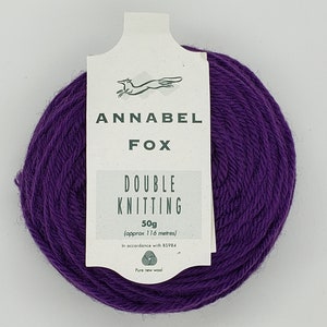 May include: A skein of purple wool yarn labeled "Annabel Fox Double Knitting 50g (approx 116 metres) In accordance with 85984 Pure new wool"