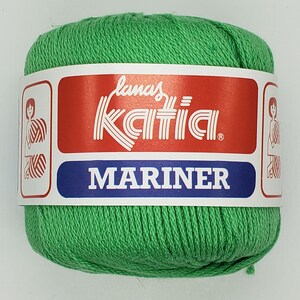 May include: A ball of green yarn with a white label that reads "Lanas Katia" and "MARINER".