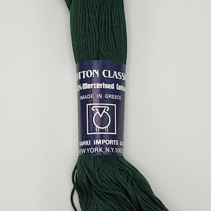May include: A spool of dark green 100% mercerized cotton embroidery floss. The label reads "Cotton Classic 100% Mercerized Cotton Made in Greece Tahki Imports Ltd. New York, N.Y. 10001".