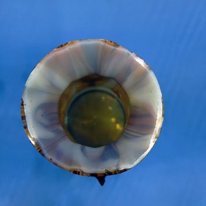 Puede incluir: Un jarr&oacute;n de vidrio blanco y marr&oacute;n con un patr&oacute;n de espiral. El jarr&oacute;n tiene una abertura ancha y una base estrecha.
